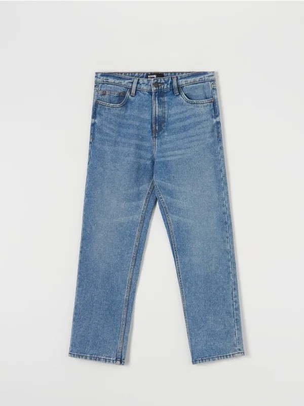 Spodnie jeansowe o kroju loose fit z modnymi przetarciami, uszyte z bawełny. - niebieski