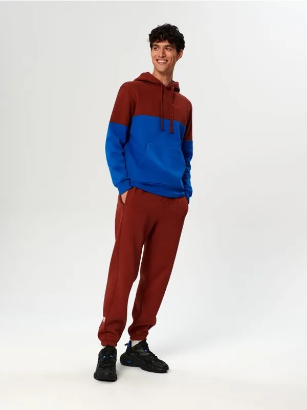 Bawełniane spodnie o kroju comfort jogger fit z ozdobną naszywką. - czerwony