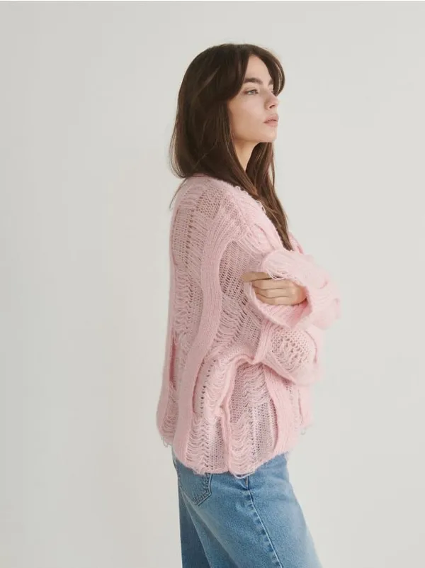 Sweter o swobodnym fasonie, wykonany ze strukturalnej dzianiny. - pastelowy róż