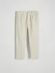 Spodnie typu carrot o regularnym kroju, wykonane z bawełnianej tkaniny. - złamana biel