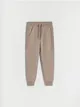 Spodnie typu jogger, wykonane z dresowej, bawełnianej dzianiny. - beżowy