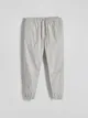 Spodnie typu jogger o dopasowanym fasonie, wykonane z bawełnianej tkaniny. - jasnoszary