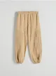 Spodnie o swobodnym fasonie, wykonane z bawełnianej tkaniny. - beżowy