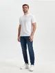 Spodnie jeansowe o kroju jogger uszyte z bawełnianej tkanin z dodatkiem elastycznych włókien. - niebieski